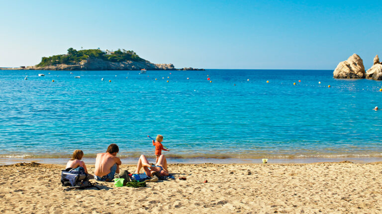 Familia disfrutando de un d&iacute;a en la playa de Sant Joan, Ibiza.