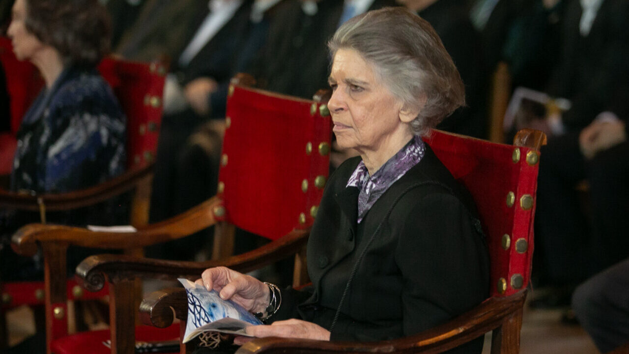 Princesa Irene de Grecia sentada en un evento con un folleto en las manos