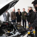 Reuni&oacute;n en estaci&oacute;n ITV con varios hombres observando un veh&iacute;culo