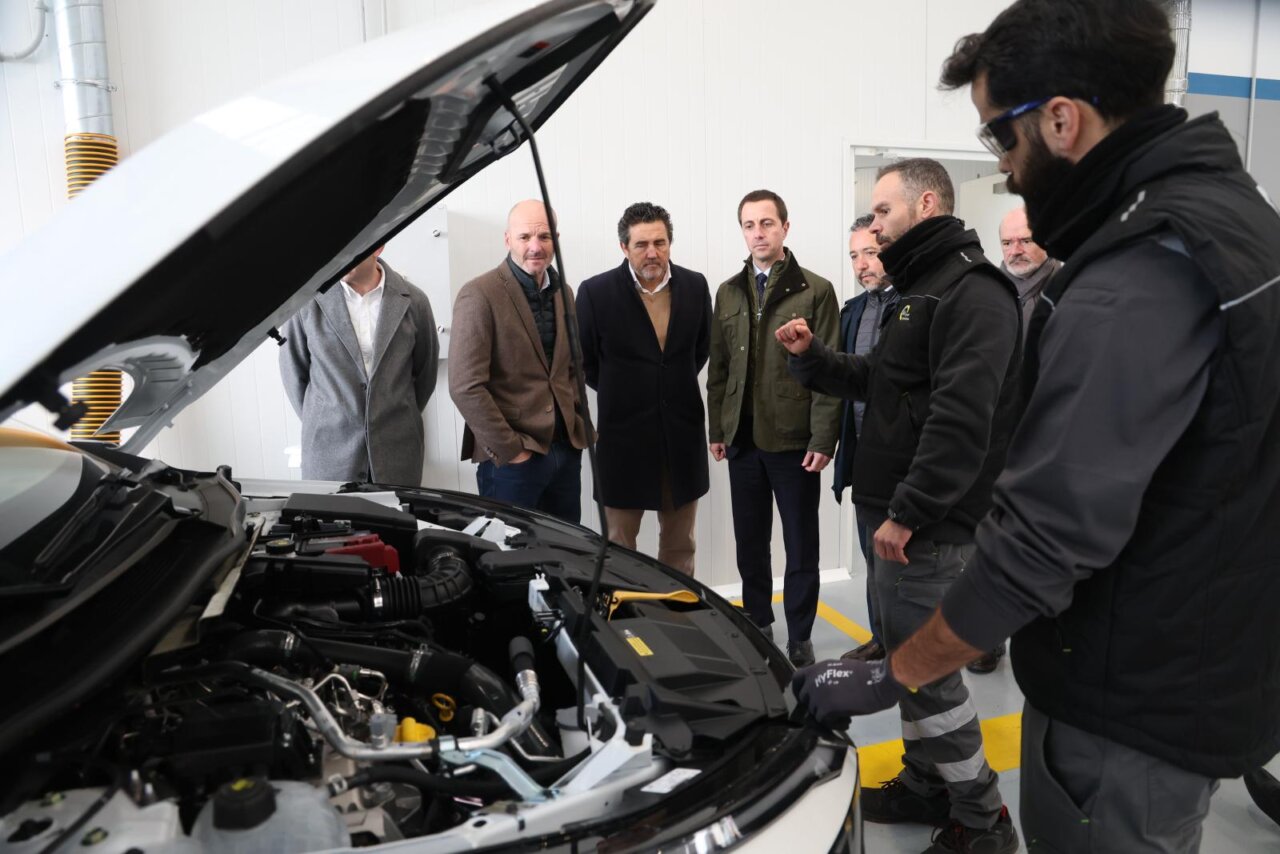 Reuni&oacute;n en estaci&oacute;n ITV con varios hombres observando un veh&iacute;culo