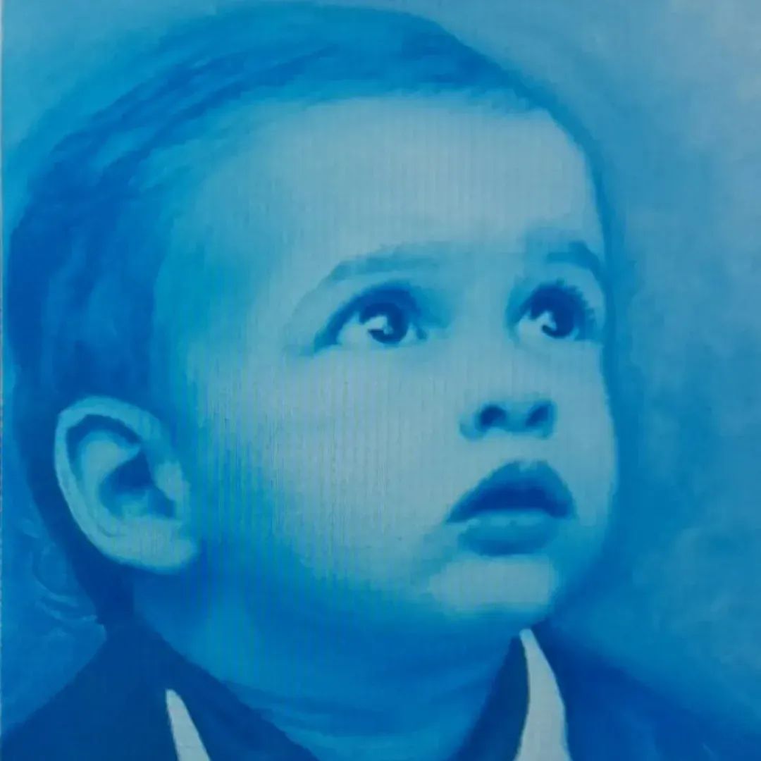 Retrato en tonos azules de un niño con mirada curiosa y expresión inocente.