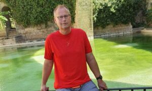 Hombre en camiseta roja junto a un estanque en Palma