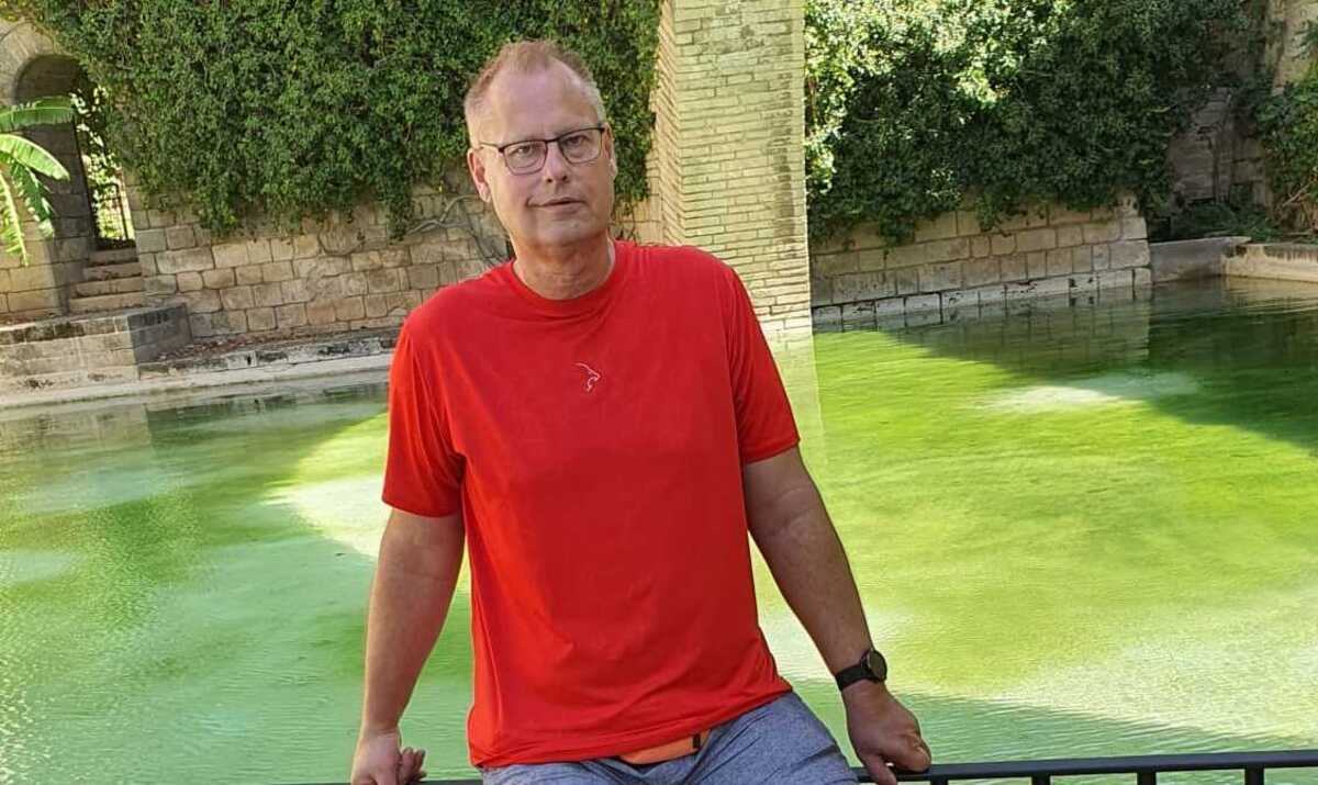 Hombre en camiseta roja junto a un estanque en Palma