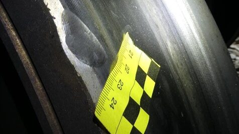 Rueda de tren con muescas y regla de medición para análisis