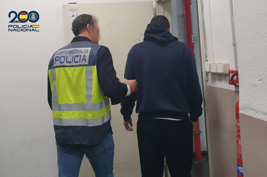 Agentes de policía deteniendo a un sospechoso en un pasillo