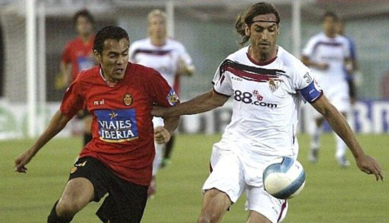 Jugadores del Sevilla y Mallorca compiten por el balón en un partido de fútbol