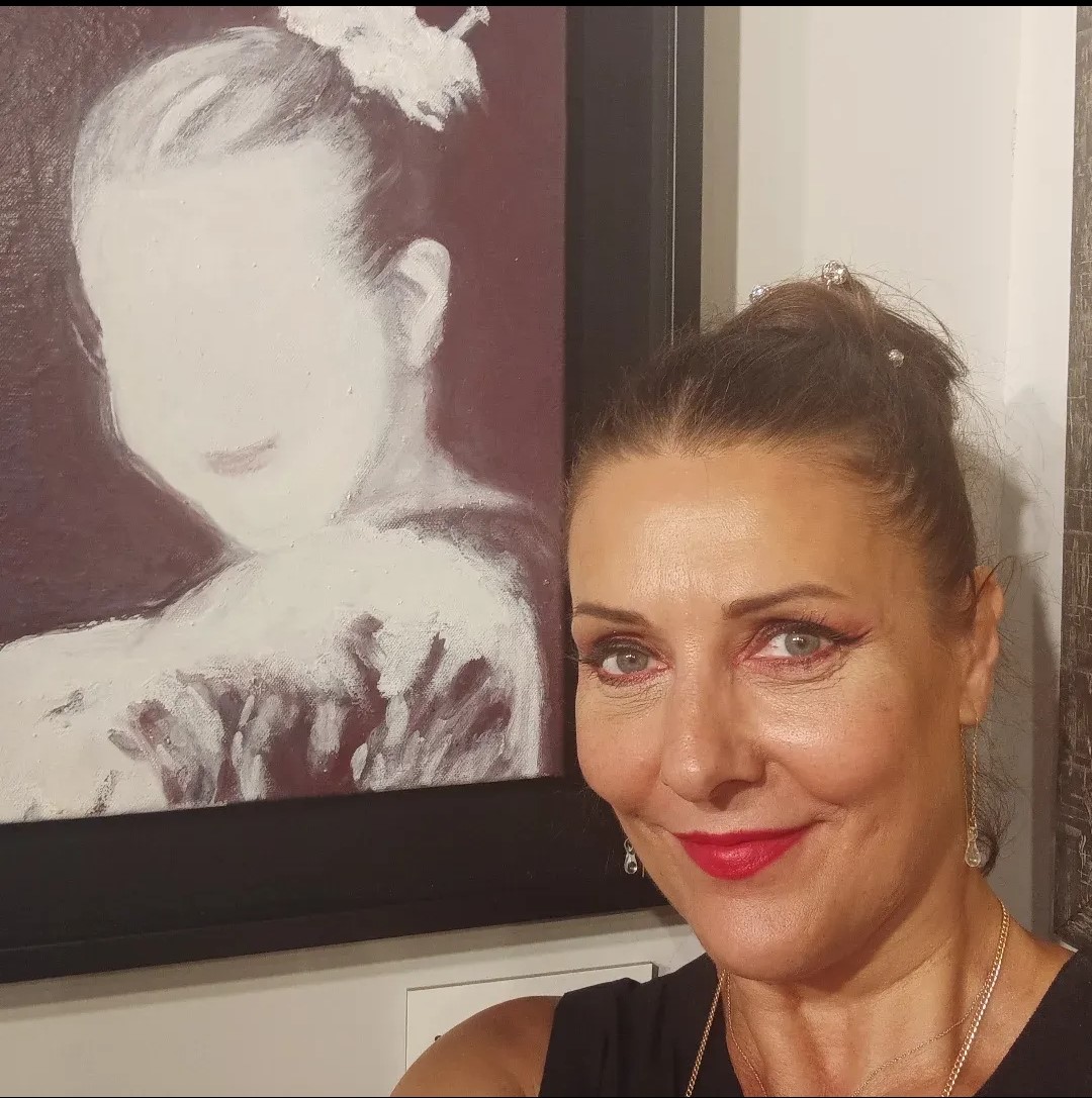 Silvina Barrera posando junto a su obra de arte en una exposición