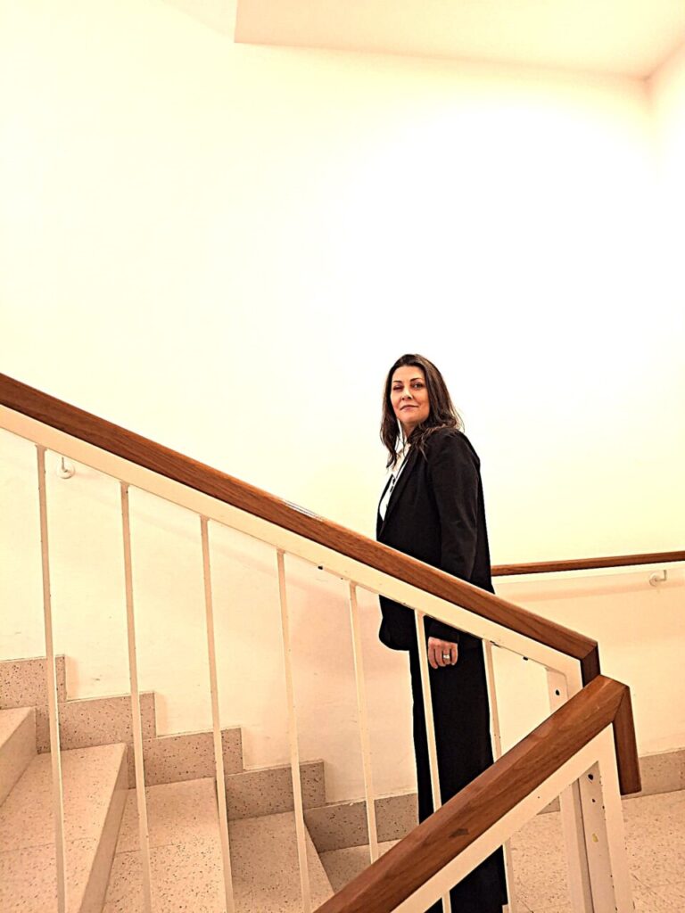 Silvina Barrera posando en una escalera con traje negro