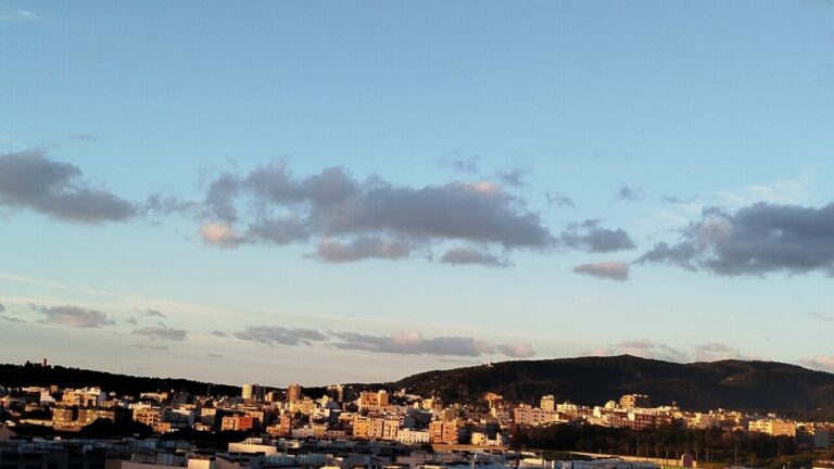 Vista de Palma con cielo poco nuboso y monta&ntilde;as al fondo