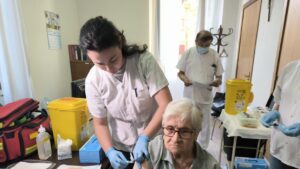 Una mujer mayor recibiendo la vacuna contra la gripe en un centro sanitario.