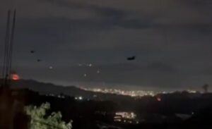 Vista nocturna de Caracas con luces y aviones en el cielo