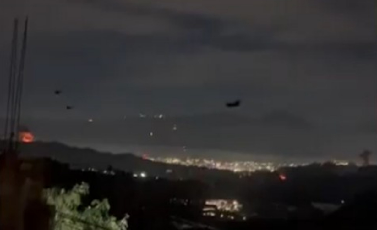 Vista nocturna de Caracas con luces y aviones en el cielo