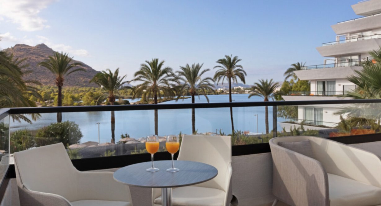 Terraza del hotel VIVA Eden Lago con vista al lago y palmeras