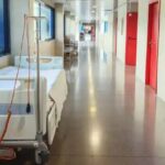 Pasillo de hospital con cama vacía y decoración moderna