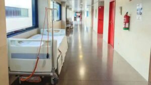 Pasillo de hospital con cama vac&iacute;a y decoraci&oacute;n moderna