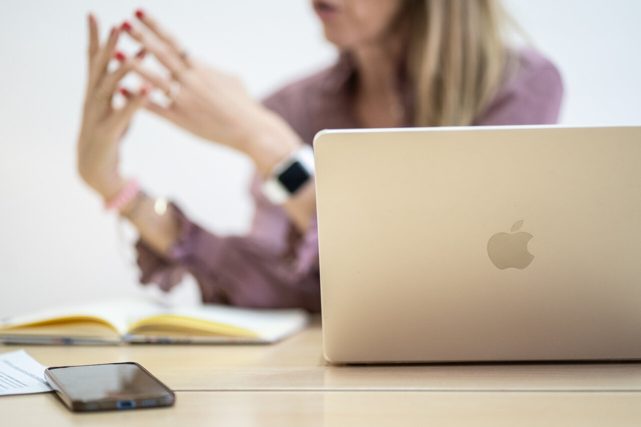 Mujer gesticulando durante una entrevista con un ordenador port&aacute;til