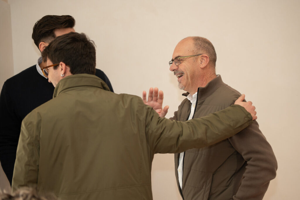 Dos hombres conversando y sonriendo en un evento social.
