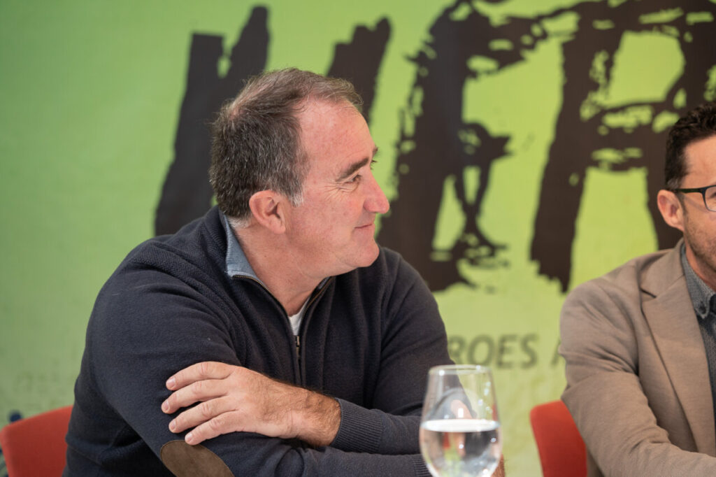 Hombre hablando en un evento de Mallorcadiario con fondo verde