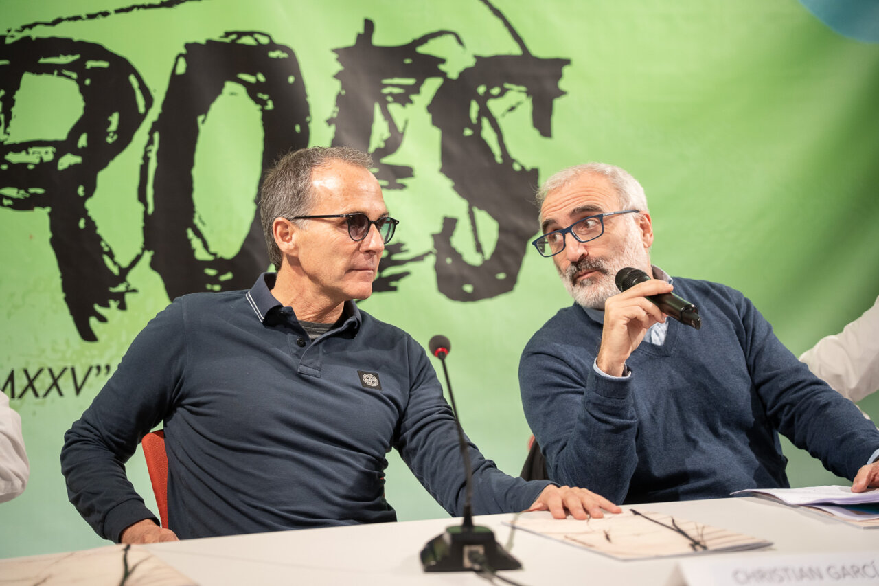 Dos hombres conversando en una mesa redonda sobre temas n&aacute;uticos.