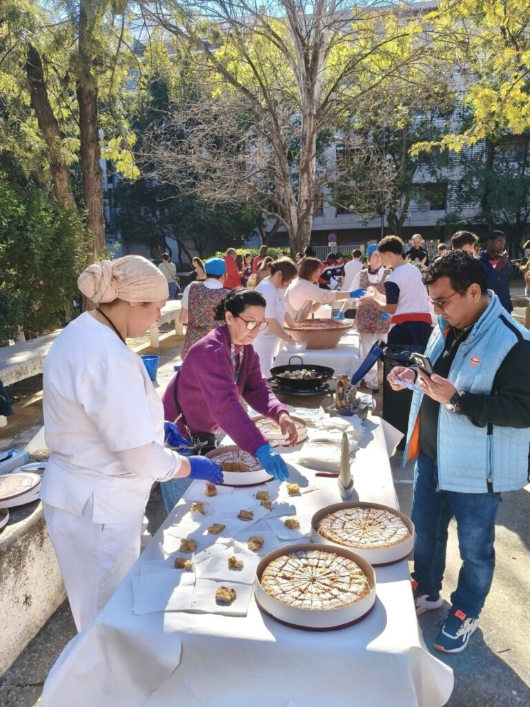 Muestra de cocina mallorquina en un colegio con varias personas cocinando.