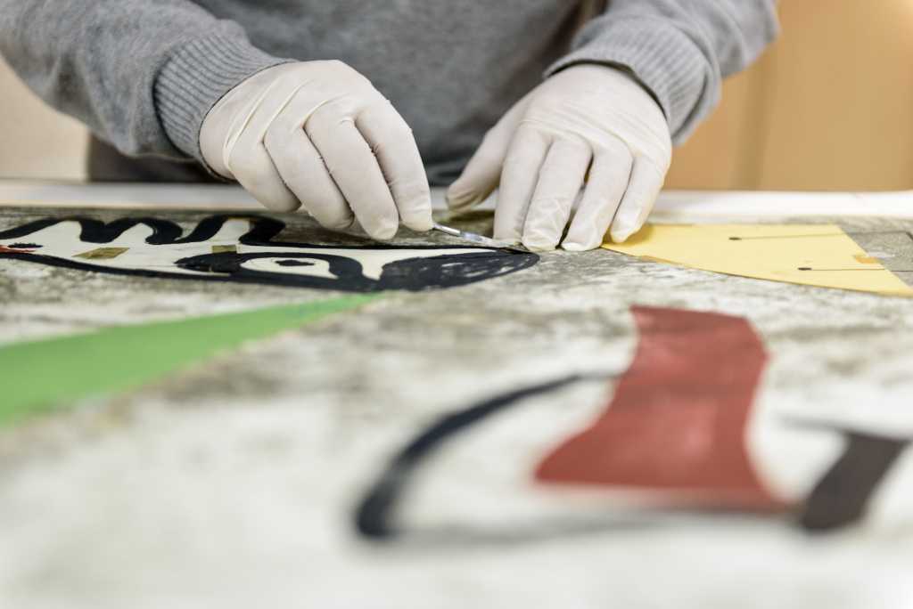 Manos con guantes trabajando en una obra de arte en la Fundaci&oacute; Mir&oacute;