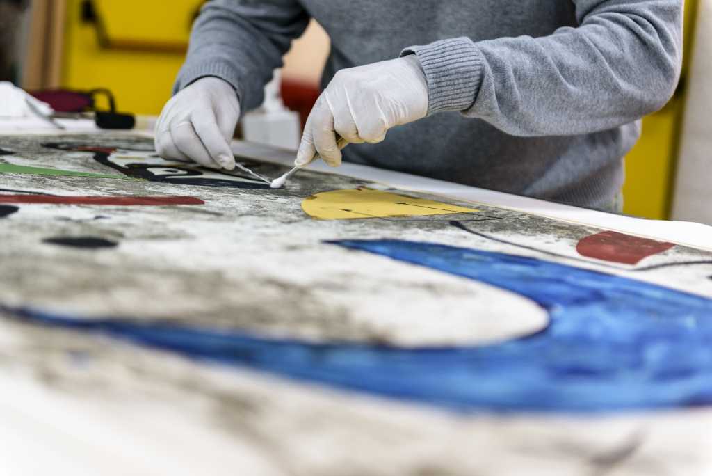 Persona limpiando una obra de arte en la Fundaci&oacute; Pilar i Joan Mir&oacute;