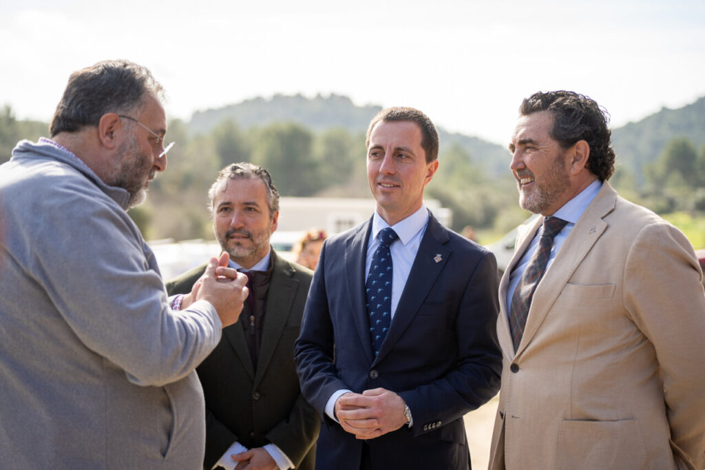 Cuatro hombres conversando en un evento al aire libre en la Sierra de Tramuntana.