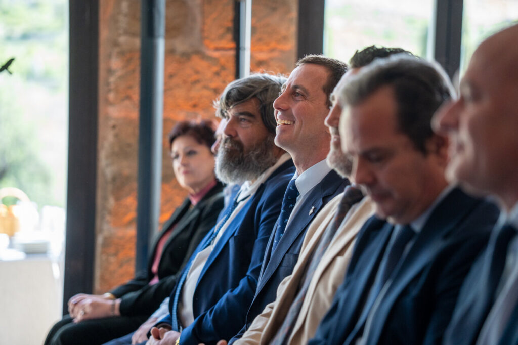 Grupo de personas sentadas en un evento con vistas a la Sierra de Tramuntana