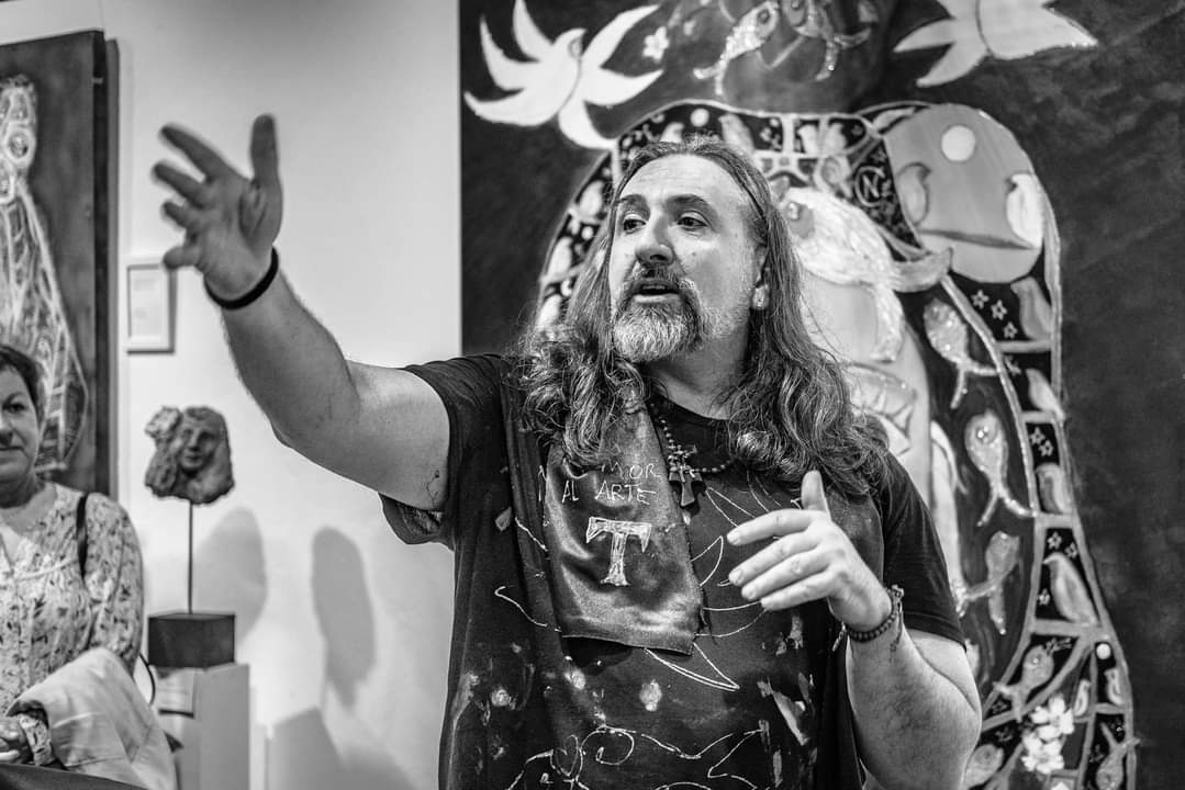 Emanuel Navarro D'Garem hablando sobre su arte en una galer&iacute;a