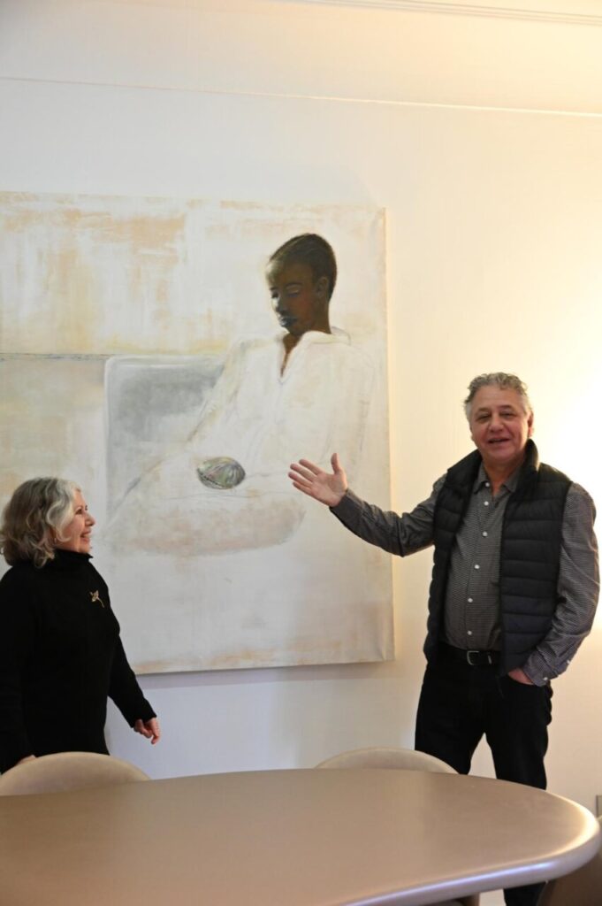 Marta Muniesa y un hombre junto a una pintura en una sala