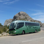 Autob&uacute;s de Viajes Simpat&iacute;a en una carretera de Mallorca con paisaje monta&ntilde;oso
