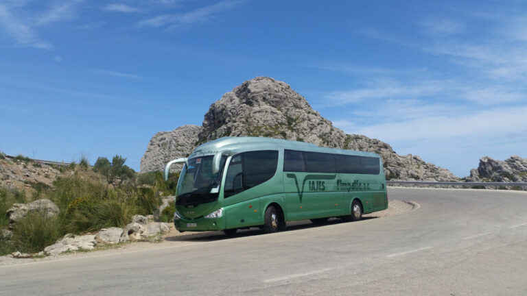 Autob&uacute;s de Viajes Simpat&iacute;a en una carretera de Mallorca con paisaje monta&ntilde;oso