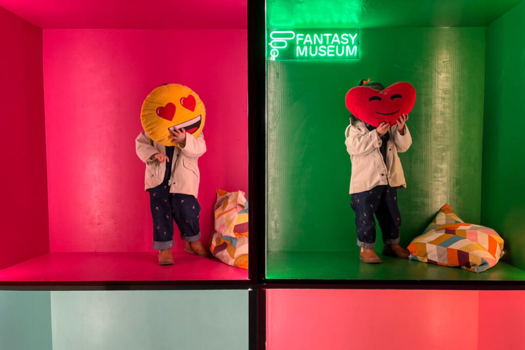 Ni&ntilde;os en un museo interactivo sosteniendo cojines con emoticonos