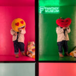 Ni&ntilde;os en un museo interactivo sosteniendo cojines con emoticonos