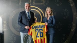 Mar&iacute;a Cruz Rivera y Jordi Horrach sosteniendo una camiseta de CaixaBank