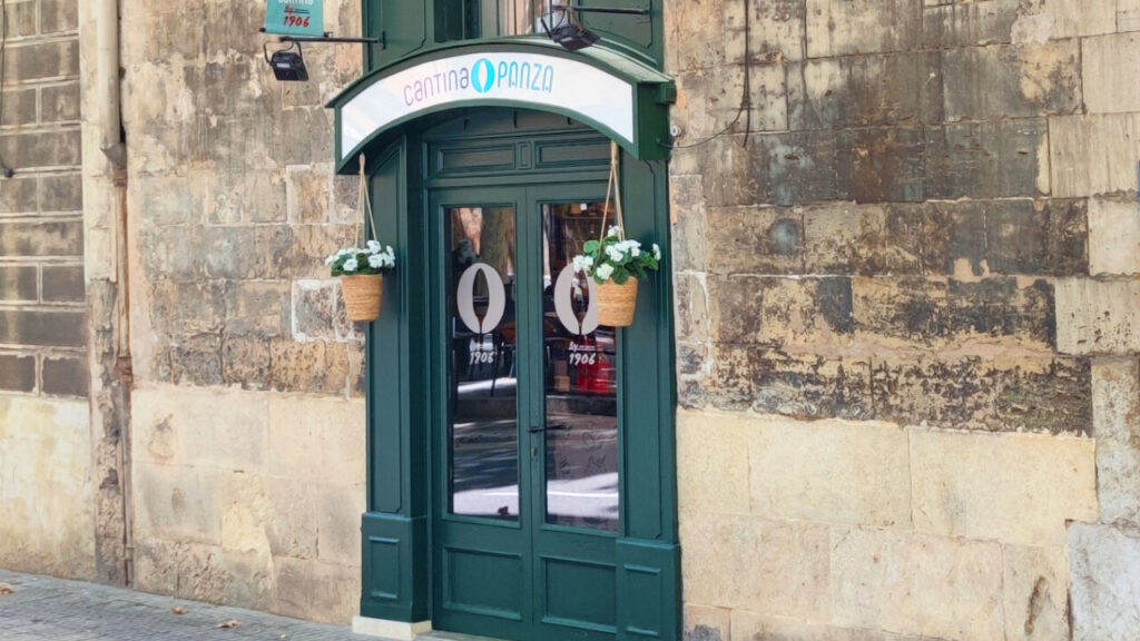 Fachada de la Cantina Panz&aacute; en Palma con flores colgantes