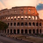Vista del Coliseo en Roma durante el atardecer con cielo colorido