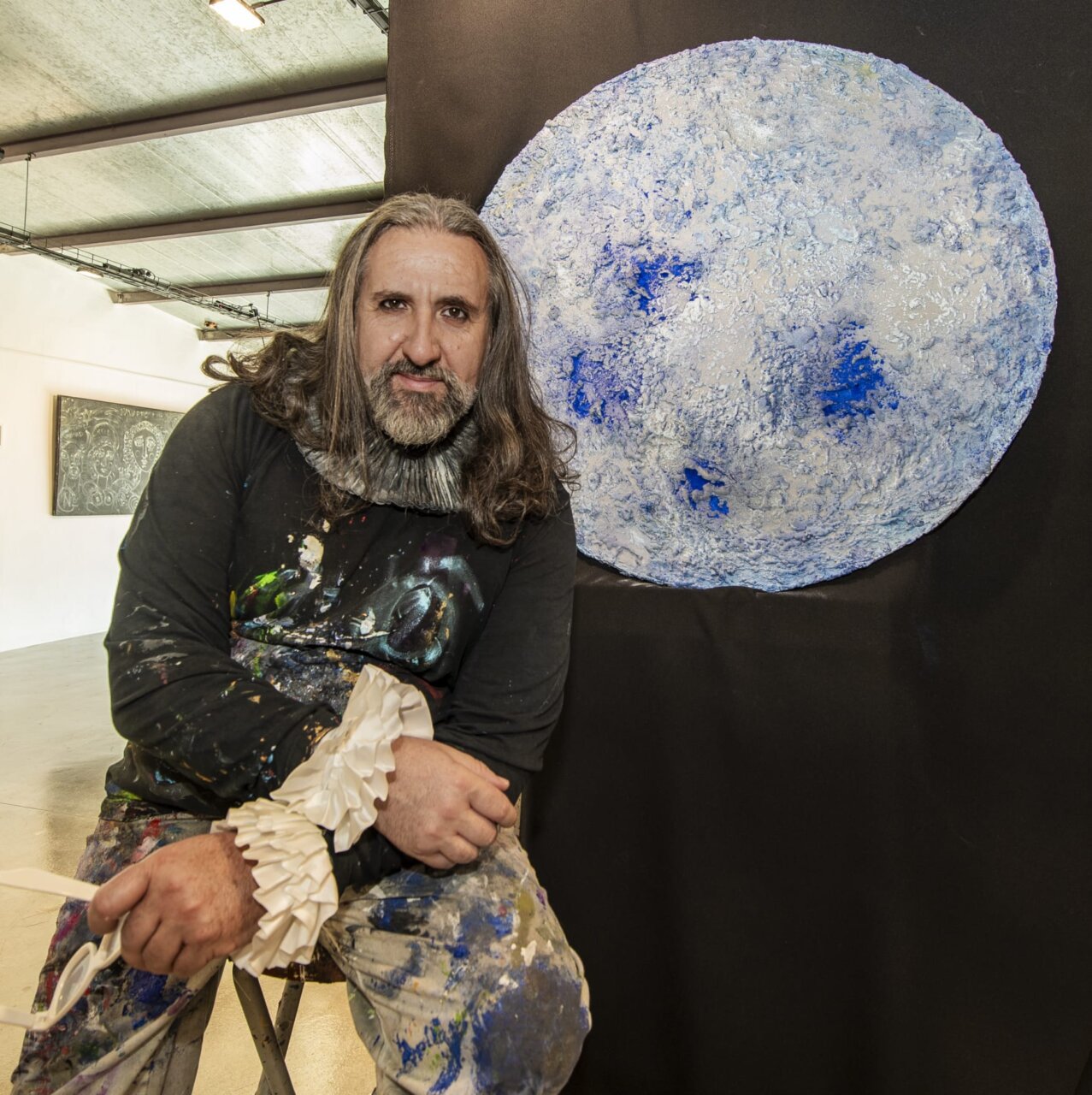 Emanuel Navarro D'Garem posando junto a su obra de arte en un estudio.