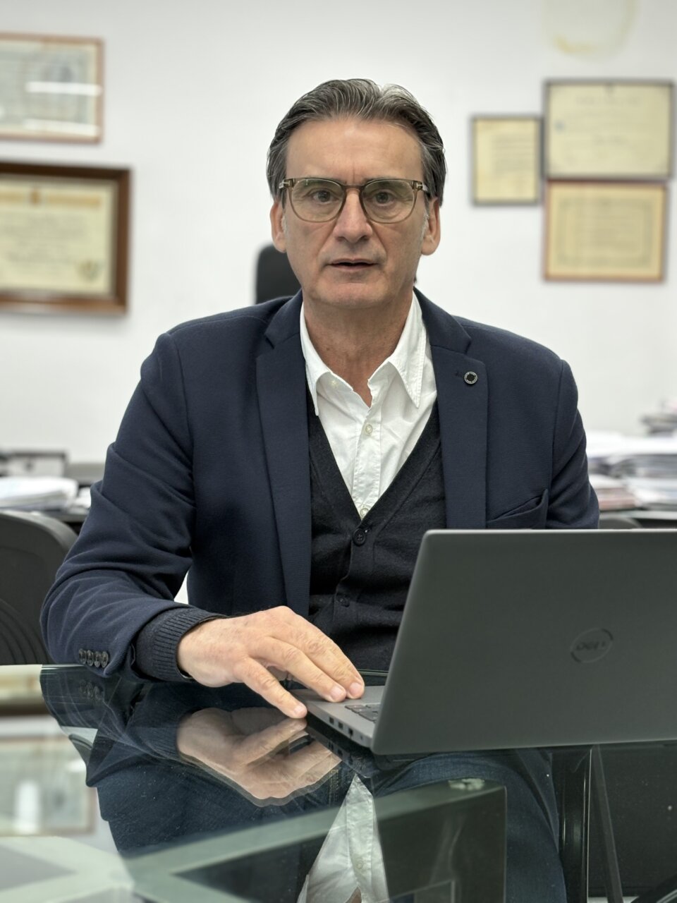 Hombre sentado frente a un ordenador en una oficina moderna.