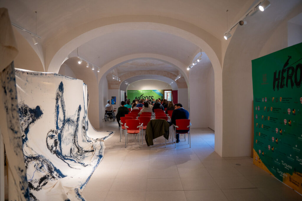 Interior de un evento con p&uacute;blico y decoraci&oacute;n art&iacute;stica