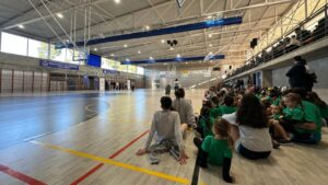 Interior del pabell&oacute;n deportivo Guillem Timoner en Felanitx con ni&ntilde;os sentados.