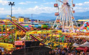 Vista de la Fira del Ram con atracciones iluminadas y visitantes