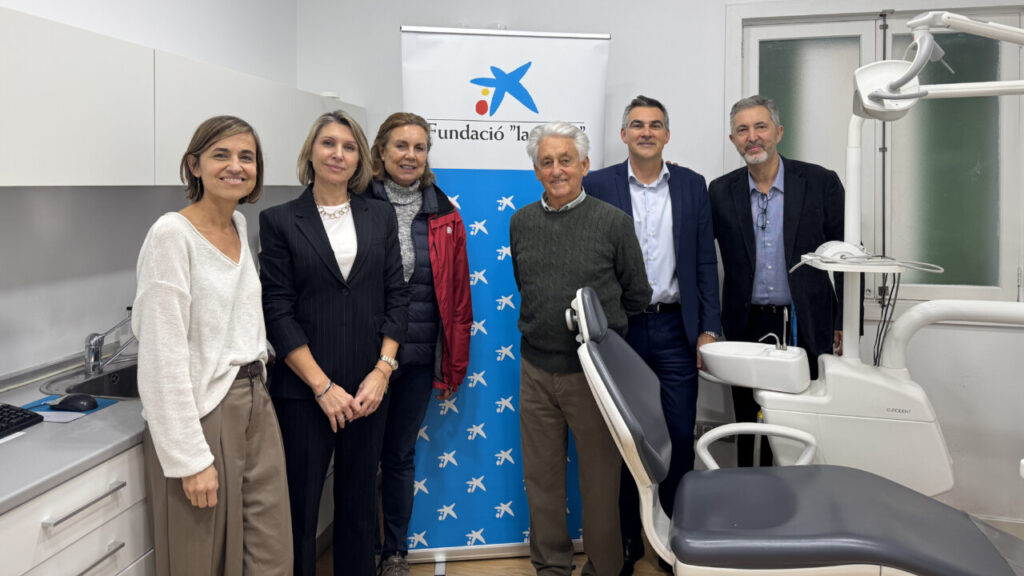 Grupo de personas en cl&iacute;nica dental con banner de Fundaci&oacute;n La Caixa
