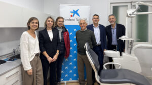 Grupo de personas en cl&iacute;nica dental con banner de Fundaci&oacute;n La Caixa