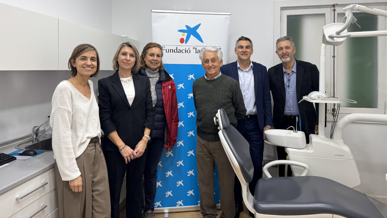 Grupo de personas en cl&iacute;nica dental con banner de Fundaci&oacute;n La Caixa