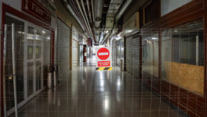 Pasillo vac&iacute;o en Galer&iacute;as Plaza Mayor con se&ntilde;al de prohibido el paso