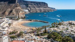 Vista panor&aacute;mica de la playa en Gran Canaria con turistas y hoteles