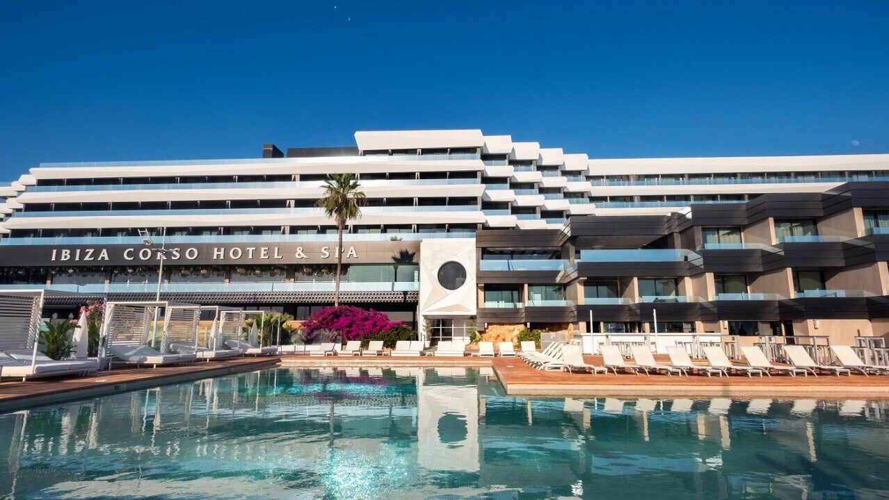Vista exterior del Hotel El Corso en Ibiza con piscina y palmeras