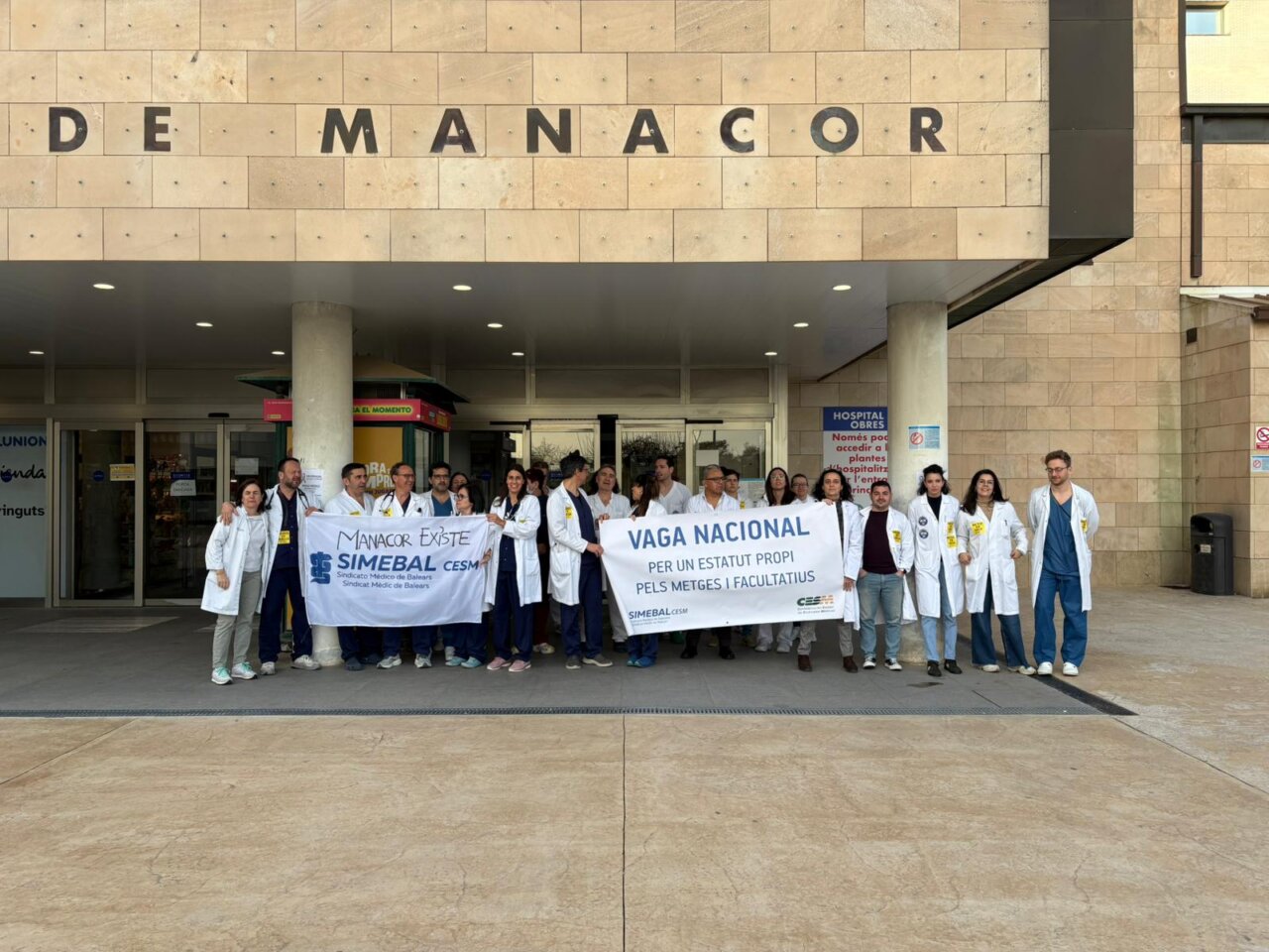 Grupo de m&eacute;dicos en huelga frente al Hospital de Manacor con pancartas.