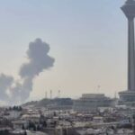 Vista de Teherán con humo en el cielo y la torre Milad